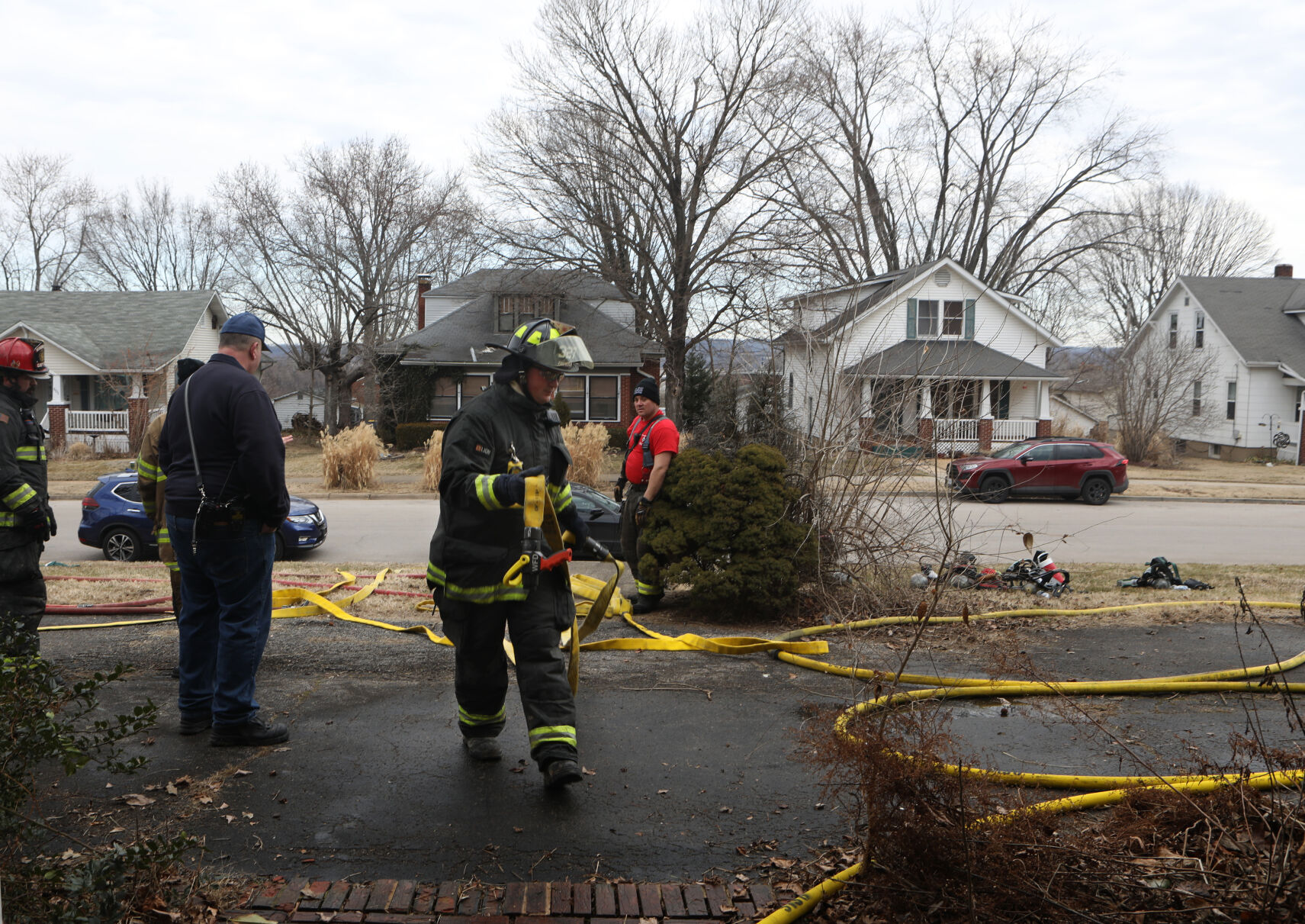 A firefighter carries hose